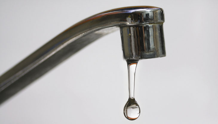 Close up image of a dripping faucet.