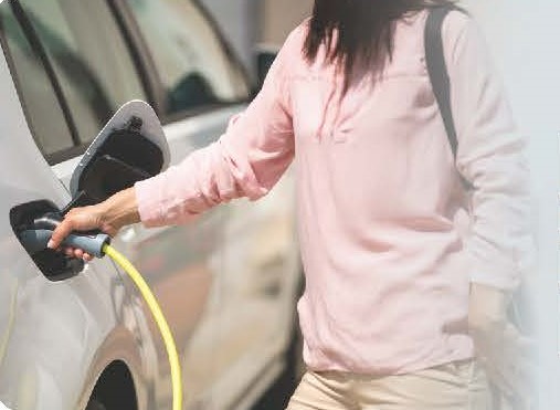 a woman charging an electric vehicle