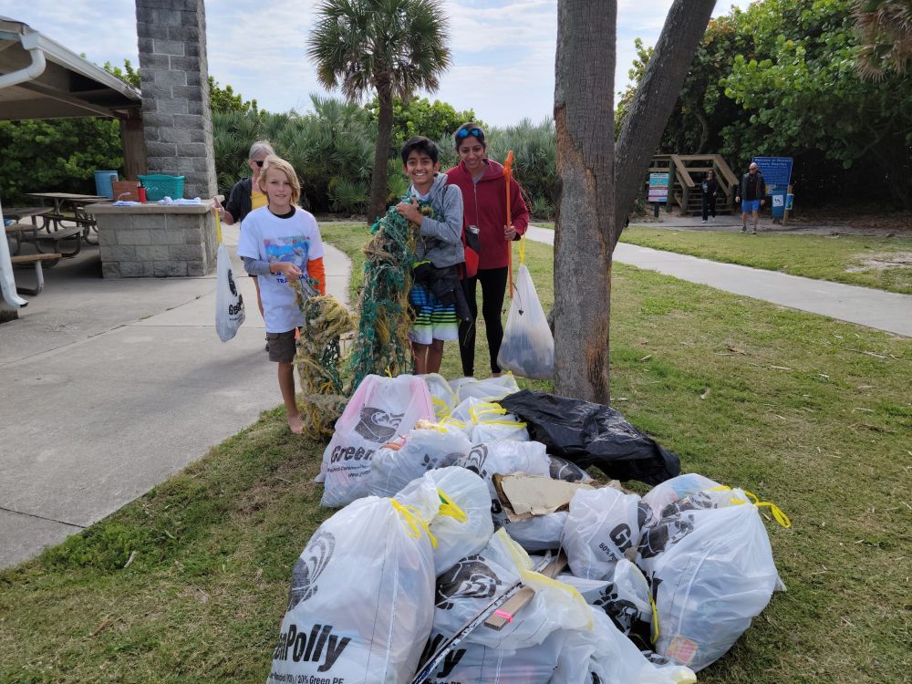 Group of Trash Bash volunteers and bags of trash at Paradise Beach Park