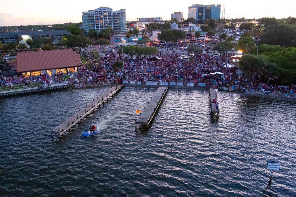 Aerial view of Front Street Civic Center and boat ramps with spectators gathered for fireworks sho.