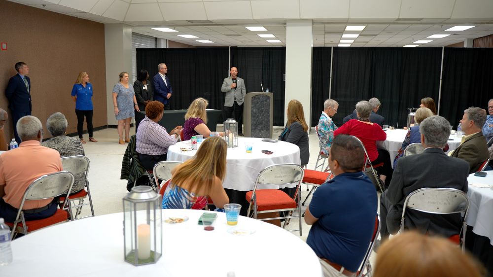 Volunteer board reception attendees at tables listening to Mayor Alfrey.