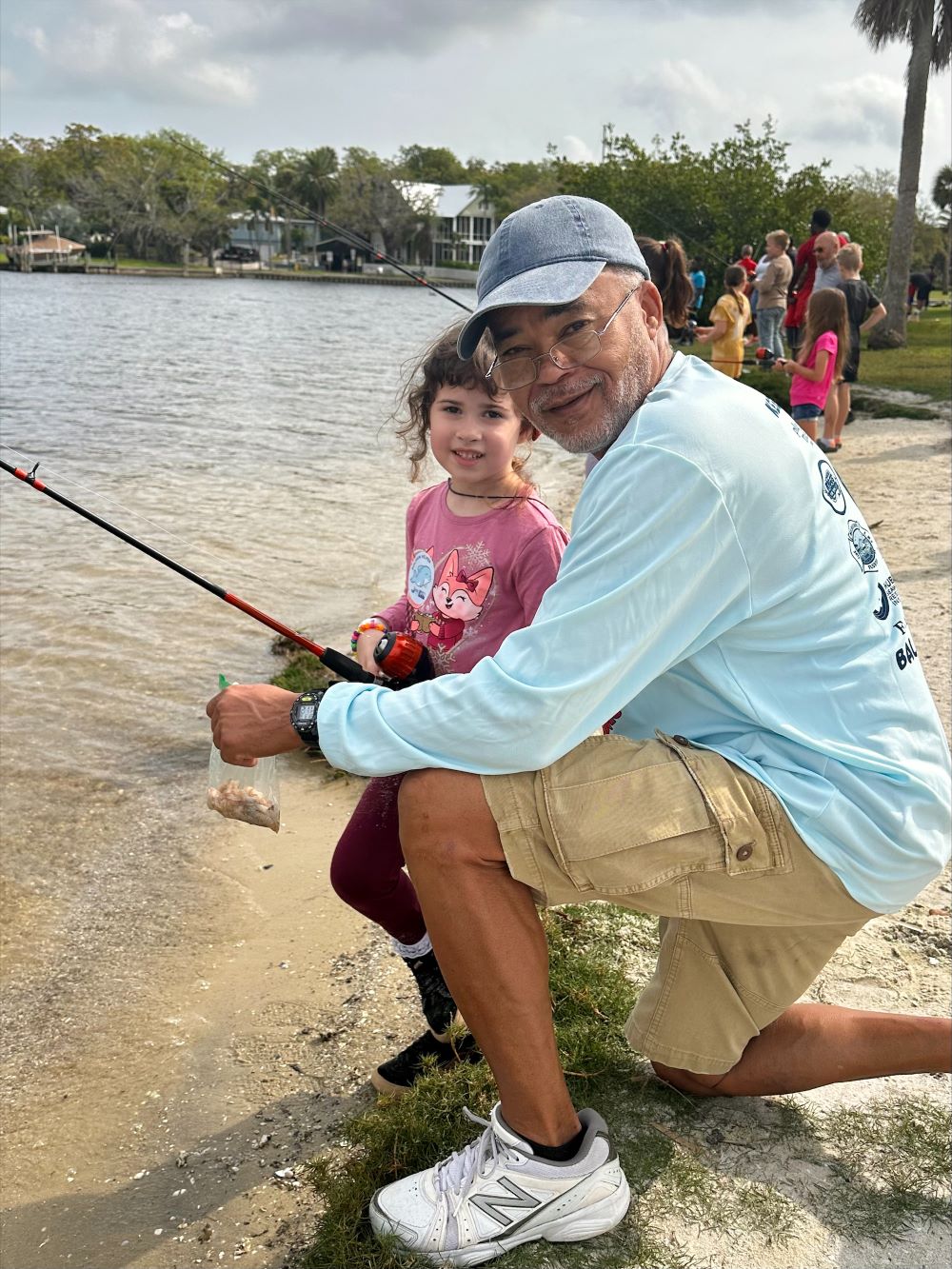 MPD officer helping young girl fish