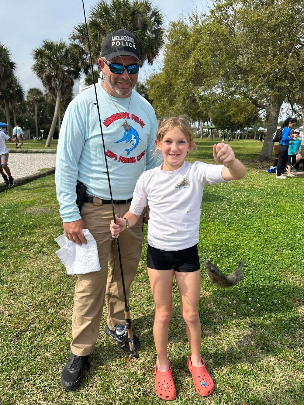 MPD officer with girl holding pole and fish