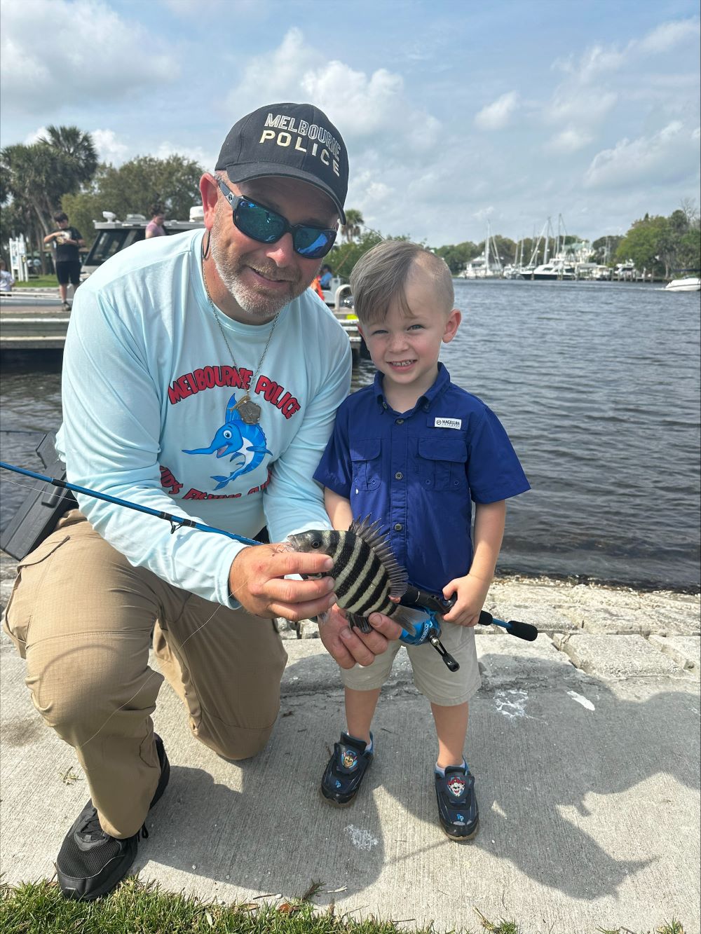 MPD officer and boy show fish they caught