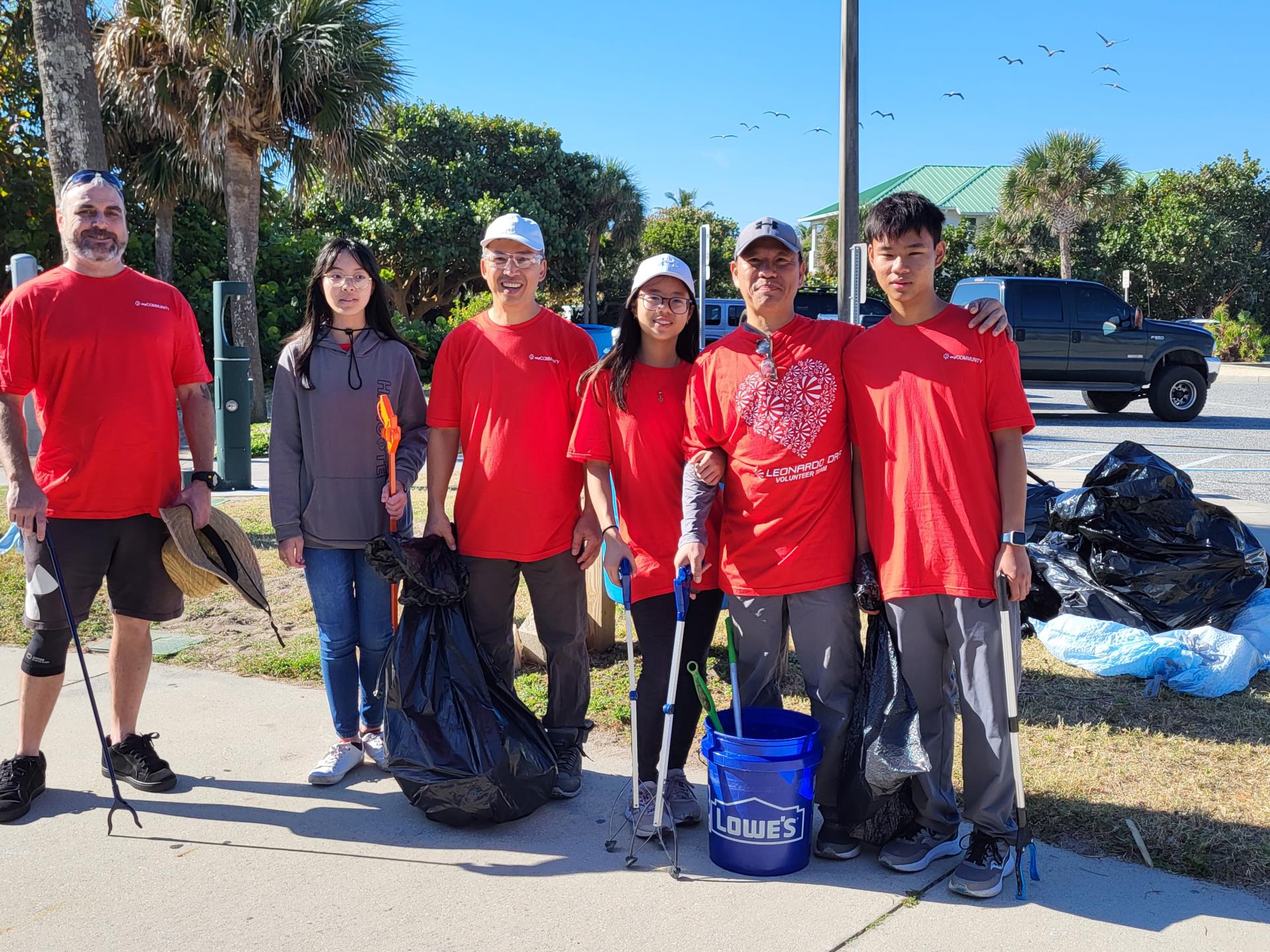 Group of six Trash Bash volunteers with clean-up tools.