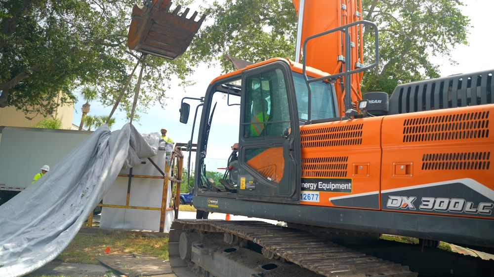 Equipment lifting stormwater pipe lining material into structure