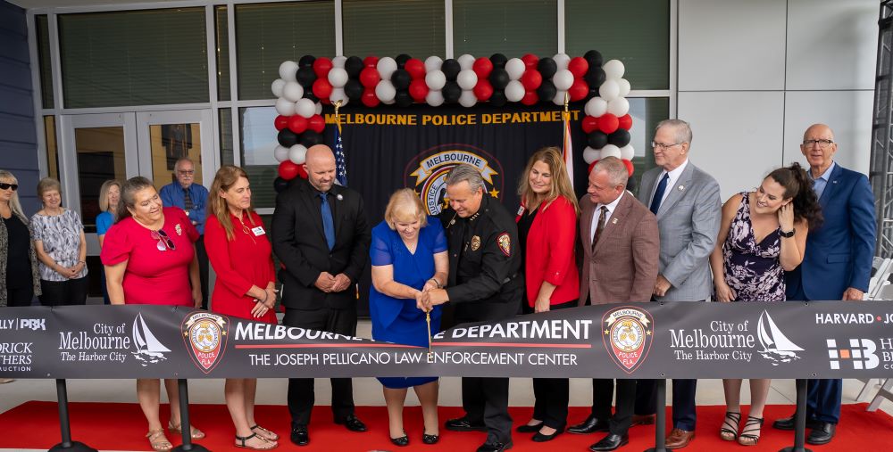 Marion Ambrose cuts the ceremonial ribbon with Council members, mayor, police chief, and Dale Hedrick